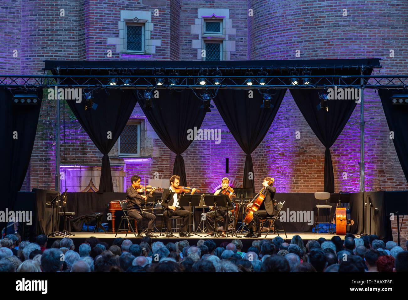 France, Tarn, Albi, classé au Patrimoine mondial de l'UNESCO, Palais de la Berbie, Musée Toulouse-Lautrec, concert de musique de chambre classique dans la cour du palais au pied du donjon la nuit devant un large public assis Banque D'Images