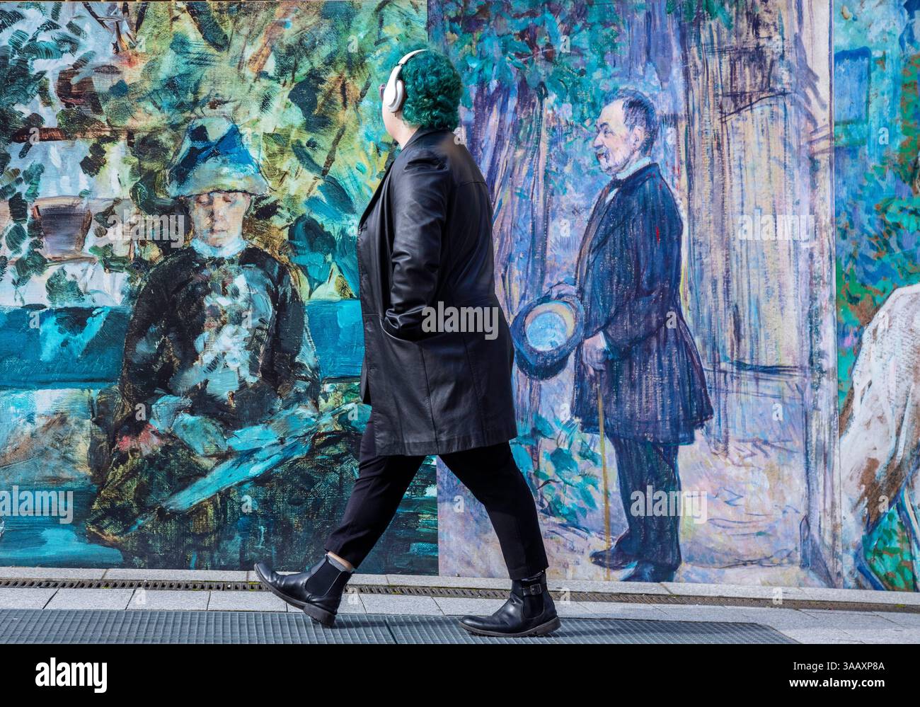 France, Occitanie, midi Pyrénées, Tarn, Albi, classé au Patrimoine mondial de l'UNESCO, passant aux cheveux bleus devant un mur d'affiches du peintre Henri de Toulouse-Lautrec Banque D'Images