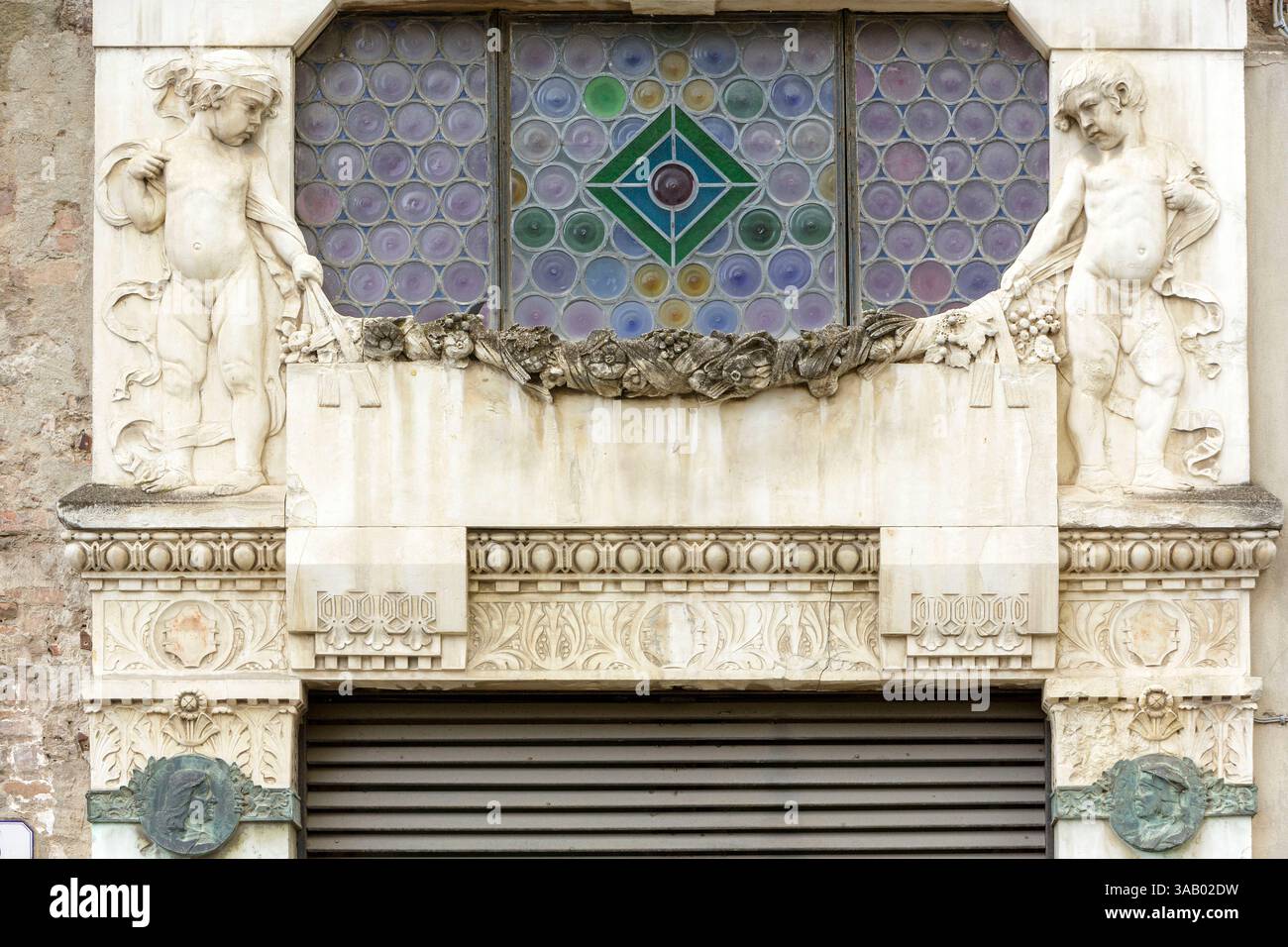 Italie, Toscane, Province de Lucques, Lucques, détail de la façade de la branche de Lucques de la Banca Nazionale del Lavoro construite au début du XXe siècle, vitrail, frise et sculptures d'enfants, situé Piazza San Michele Banque D'Images