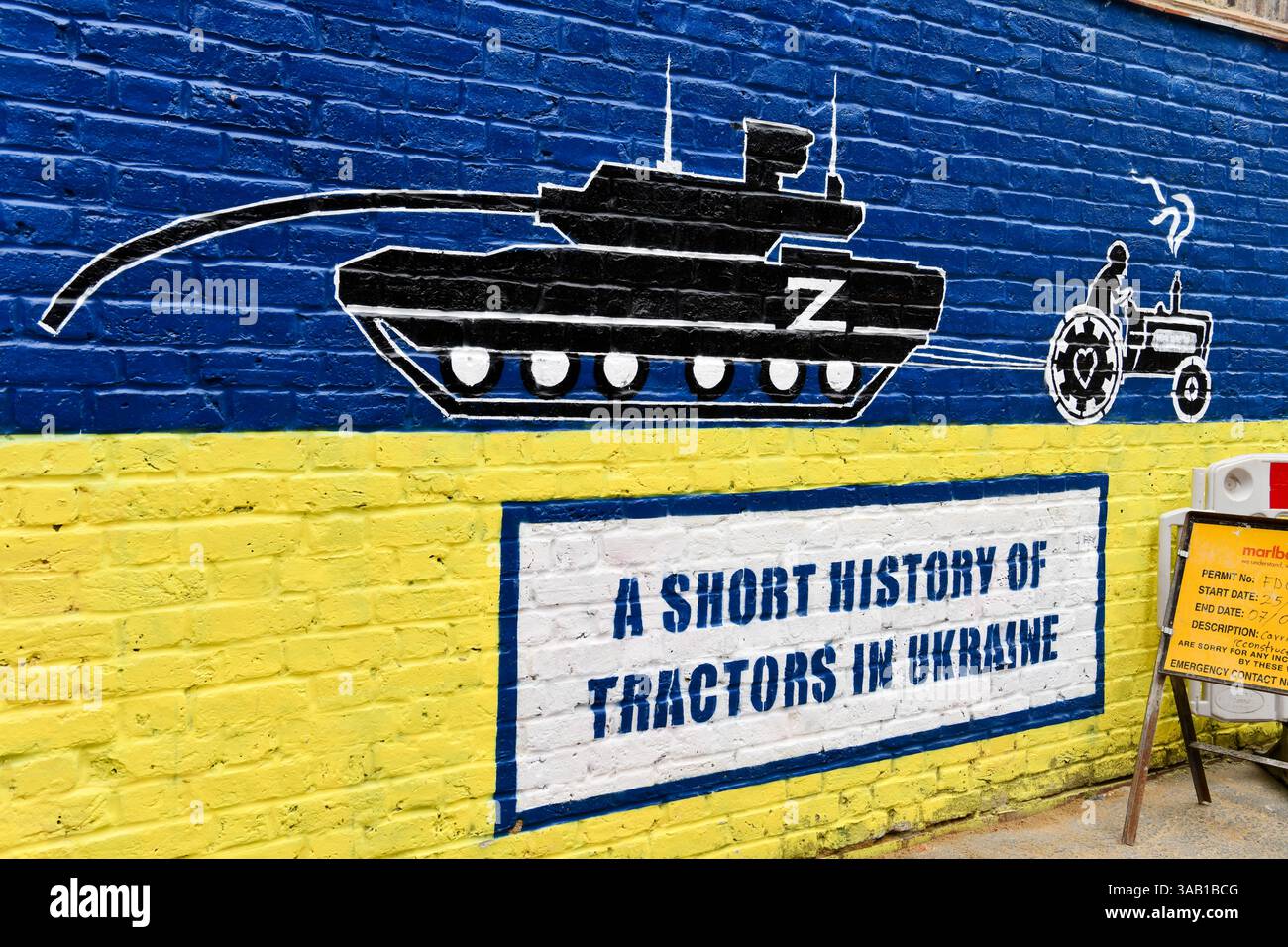Street art de tracteur remorquant char russe basé sur le livre, A Short History of Tractors in Ukraine, sur le mur à Shoreditch, Londres Banque D'Images