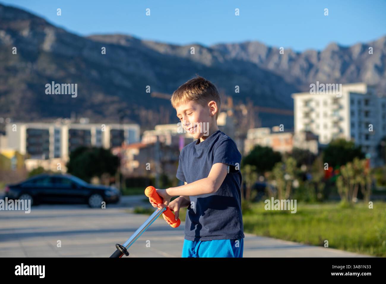 Garçon diabétique en scooter, souriant, capteur de glucose visible. Banque D'Images