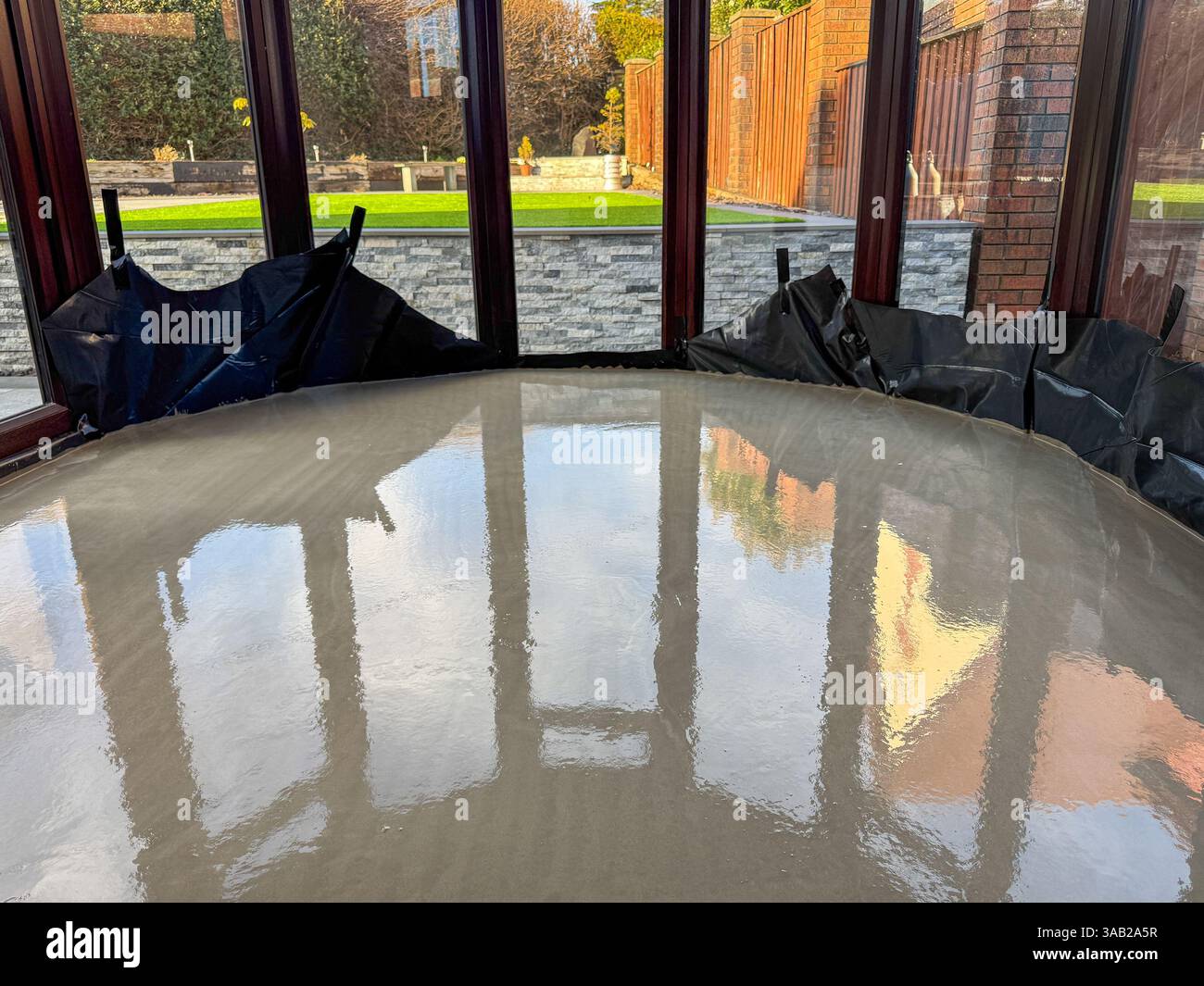 Béton humide nouvellement posé sur le sol d'une véranda d'une maison. Personne. Banque D'Images Béton humide nouvellement posé sur le sol d'une véranda d'une maison. Personne. Banque D'Images