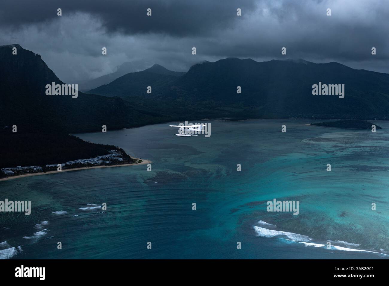 Photo aérienne d'un hydravion volant au-dessus de la célèbre illusion de cascade sous-marine près du Morne, Maurice, avec des nuages sombres et un paysage marin spectaculaire. Banque D'Images