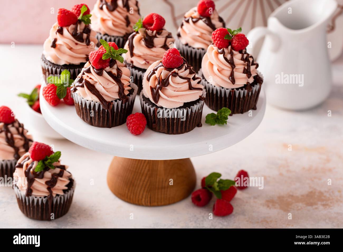 Cupcakes au chocolat à la framboise avec crème au beurre de framboise un filet de glaçage au chocolat Banque D'Images