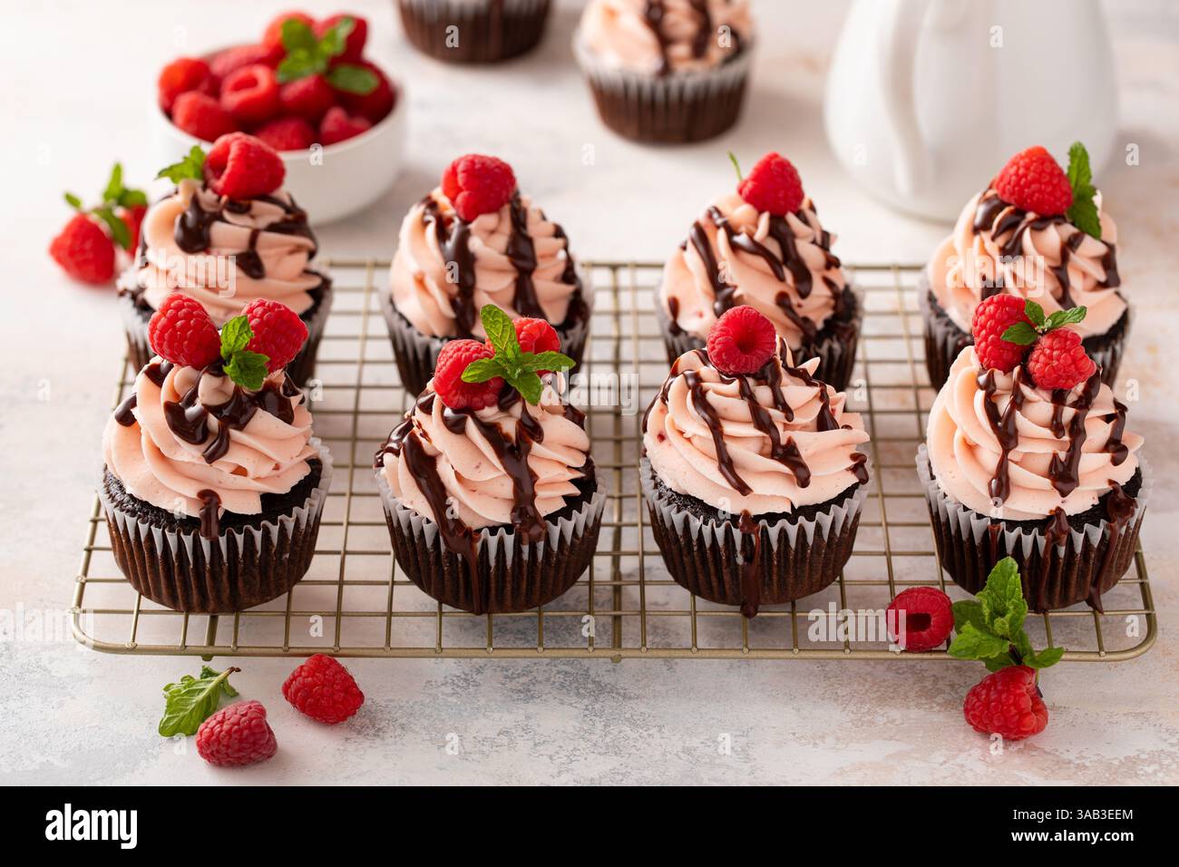 Cupcakes au chocolat à la framboise avec crème au beurre de framboise un filet de glaçage au chocolat Banque D'Images