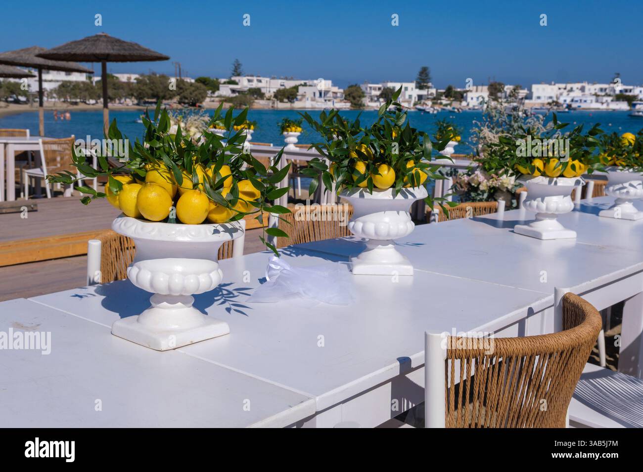 Tables de mariage avec des pièces maîtresses de citron au bord de la mer à Pollonia, Milos Banque D'Images