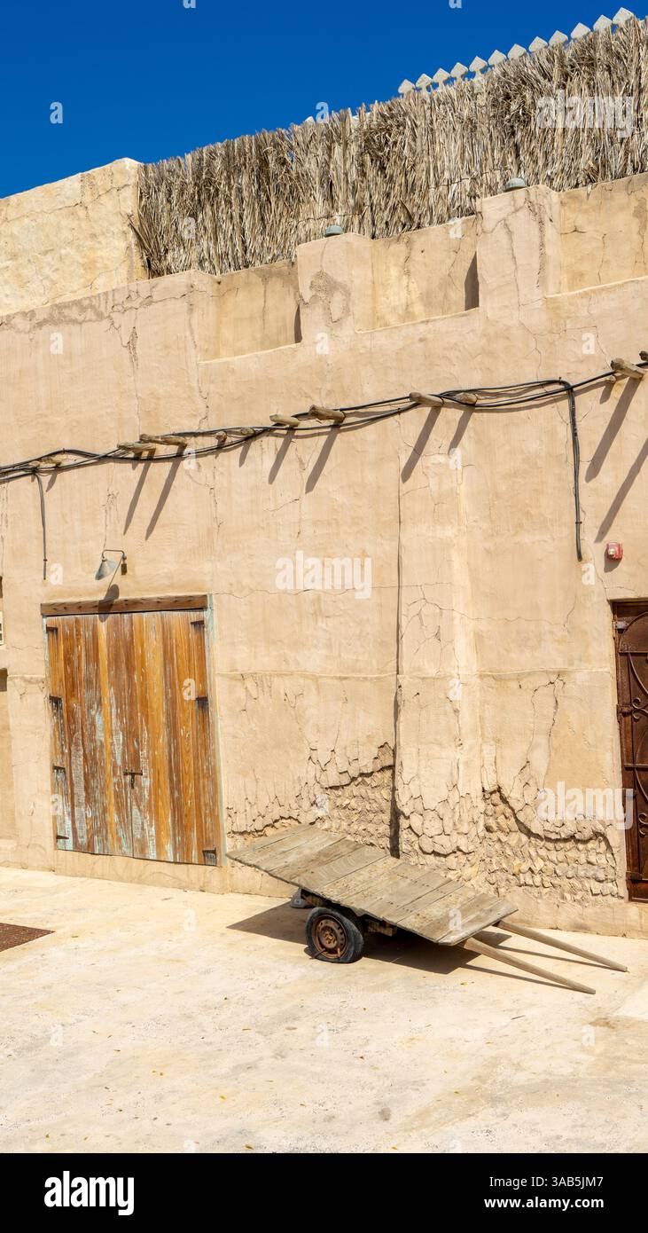 Porte brune en bois de bâtiment sur la rue de Dubaï vieille ville ou ville ou vieux village Al Seef Khor dans le quartier Al Fahidi, Émirats arabes Unis. Vertica Banque D'Images