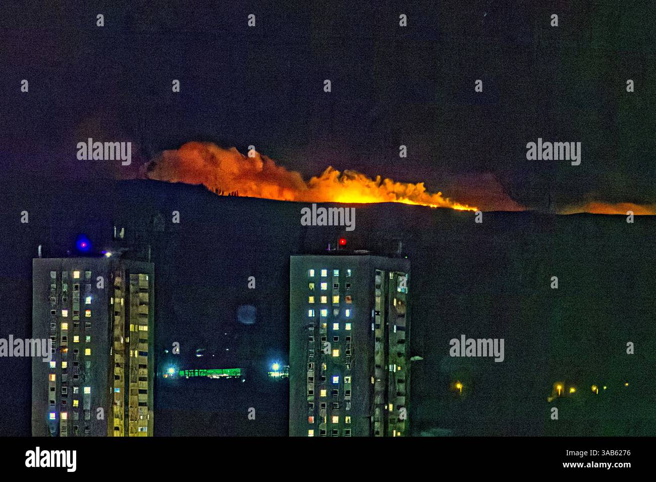 Glasgow, Écosse, Royaume-Uni. 1er avril 2025. Météo britannique : le printemps voit le temps d'été comme Un feu de forêt apparaît ce soir dans les collines kilpatrick Cochno Reservoir dans l'ouest du Dunbartonshire au-dessus du domaine du conseil de drunchapel dans le nord de la cit le deuxième dans ces collines en une semaine. Crédit Gerard Ferry/Alamy Live News Banque D'Images