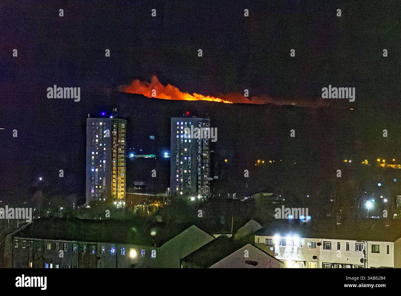 Glasgow, Écosse, Royaume-Uni. 1er avril 2025. Météo britannique : le printemps voit le temps d'été comme Un feu de forêt apparaît ce soir dans les collines kilpatrick Cochno Reservoir dans l'ouest du Dunbartonshire au-dessus du domaine du conseil de drunchapel dans le nord de la cit le deuxième dans ces collines en une semaine. Crédit Gerard Ferry/Alamy Live News Banque D'Images
