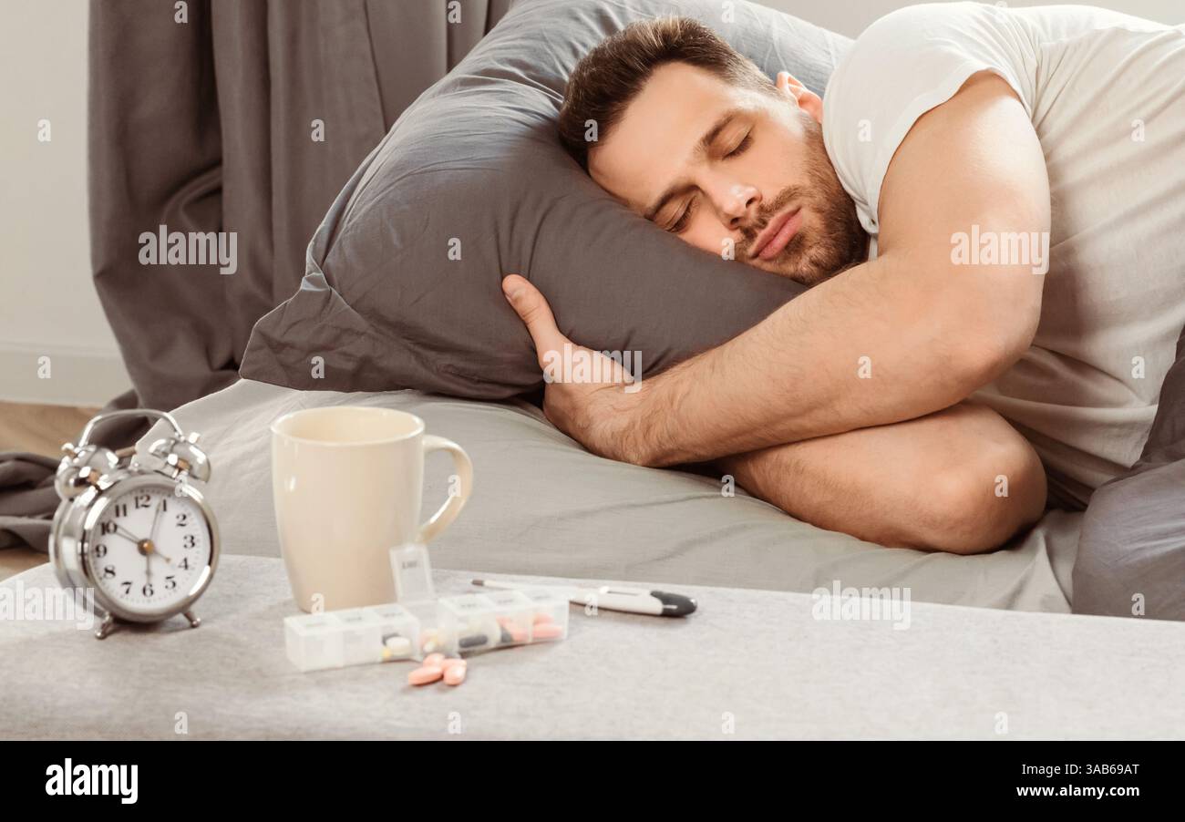 Malade Homme endormi ayant de la fièvre couché dans le lit à la maison Banque D'Images