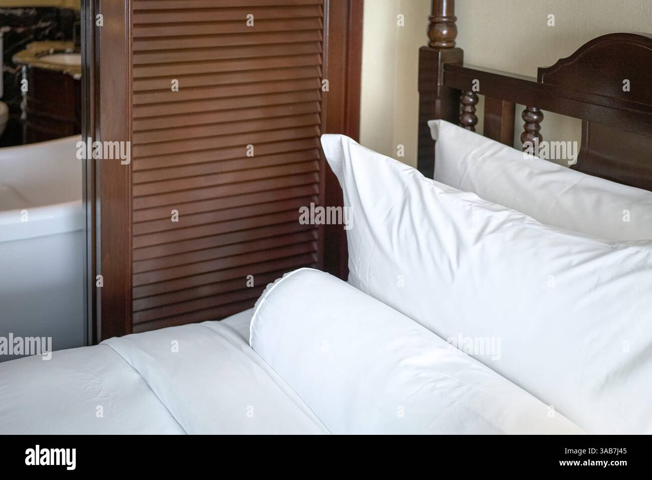Lit avec oreillers blancs, traversin et couverture. Banque D'Images