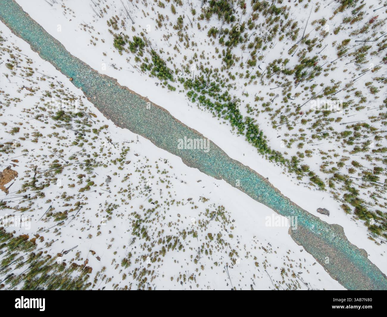 Une superbe rivière glaciaire serpentant à travers un terrain montagneux accidenté, présentant des eaux bleues immaculées et des paysages alpins spectaculaires. Banque D'Images
