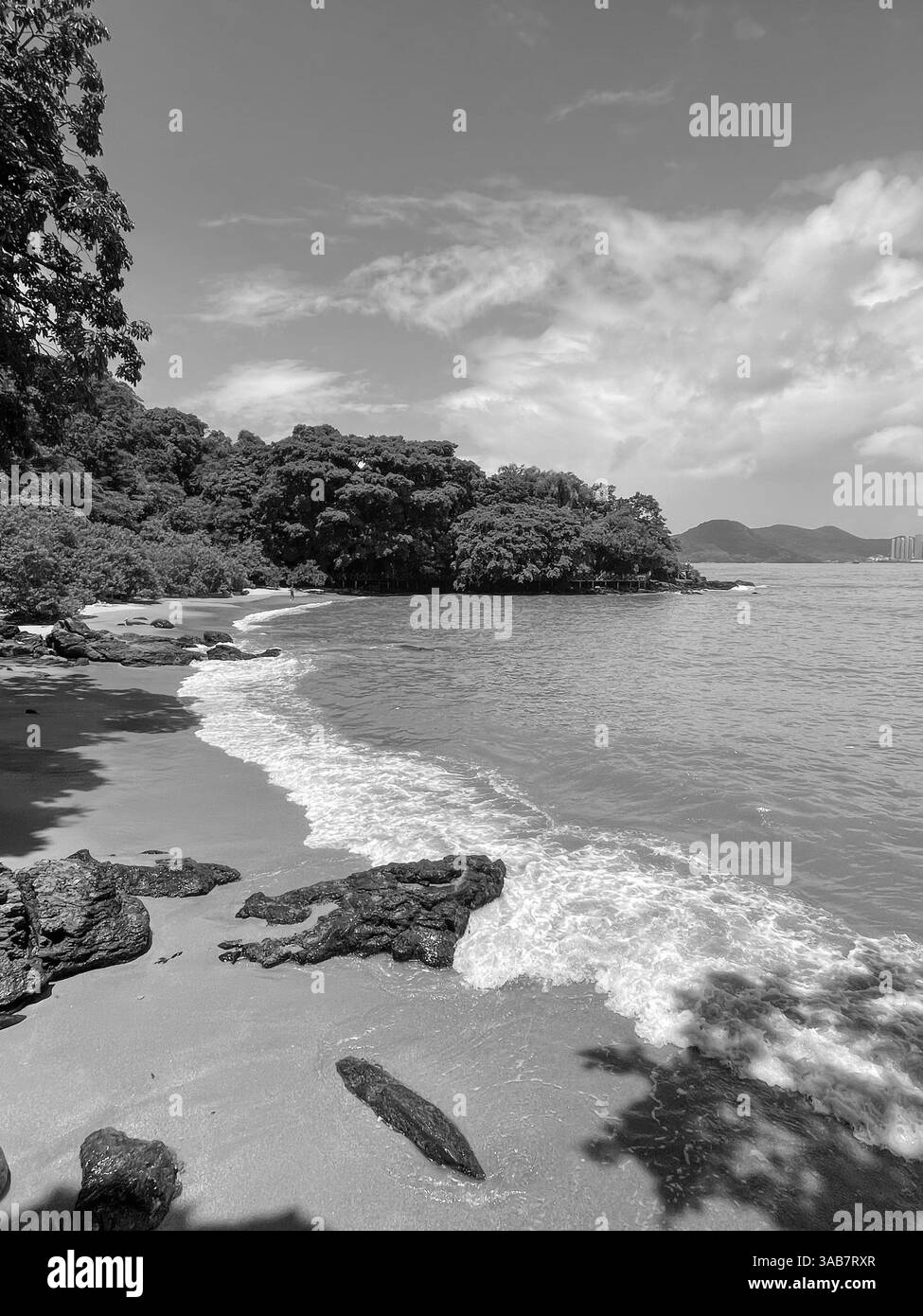 Plage tropicale rocheuse avec des collines verdoyantes et des vagues écrasantes au Brésil. Banque D'Images Plage tropicale rocheuse avec des collines verdoyantes et des vagues écrasantes au Brésil. Banque D'Images