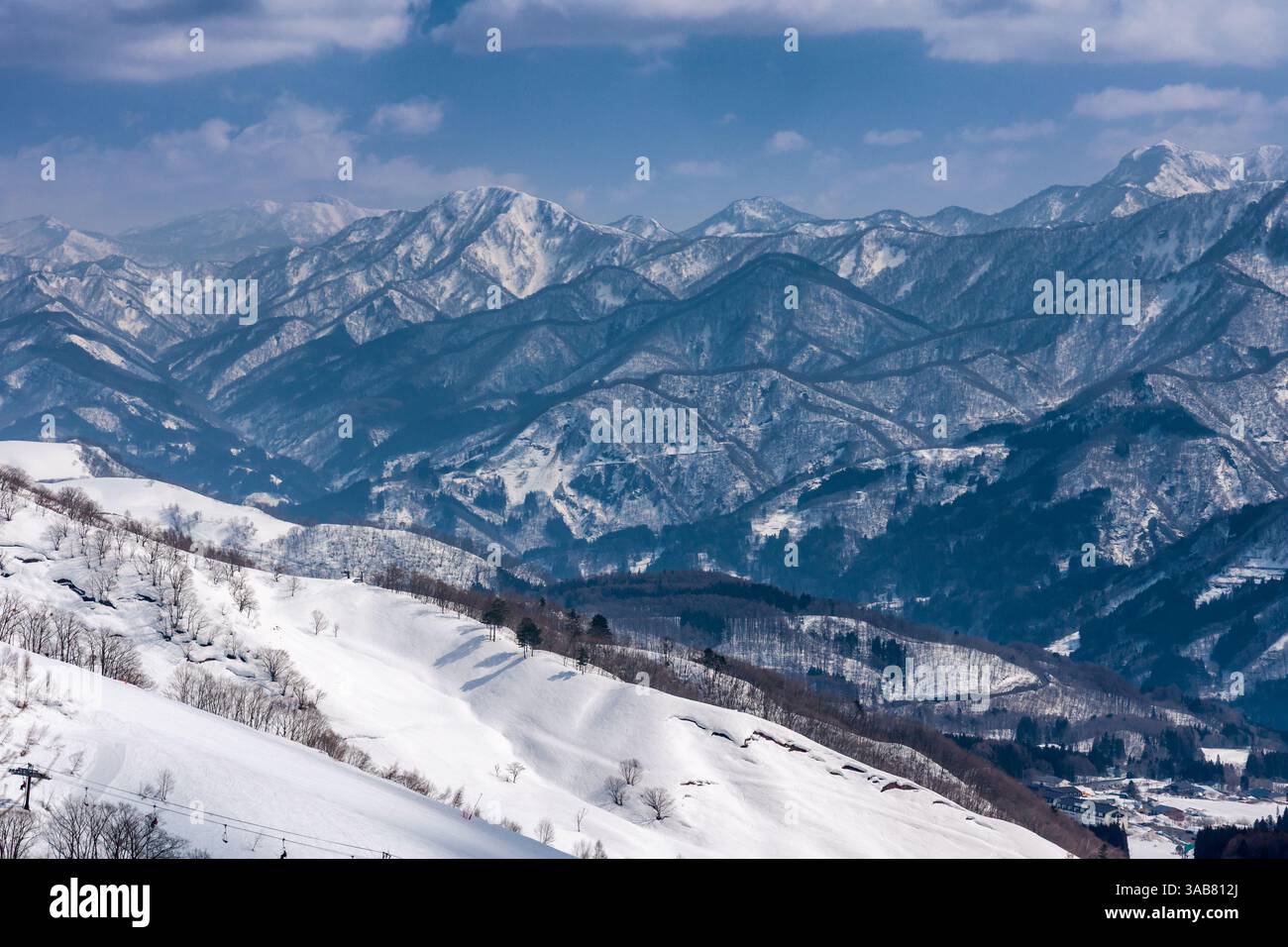 Paysage enneigé avec des sommets de montagne lointains et dentelés par une journée ensoleillée Banque D'Images
