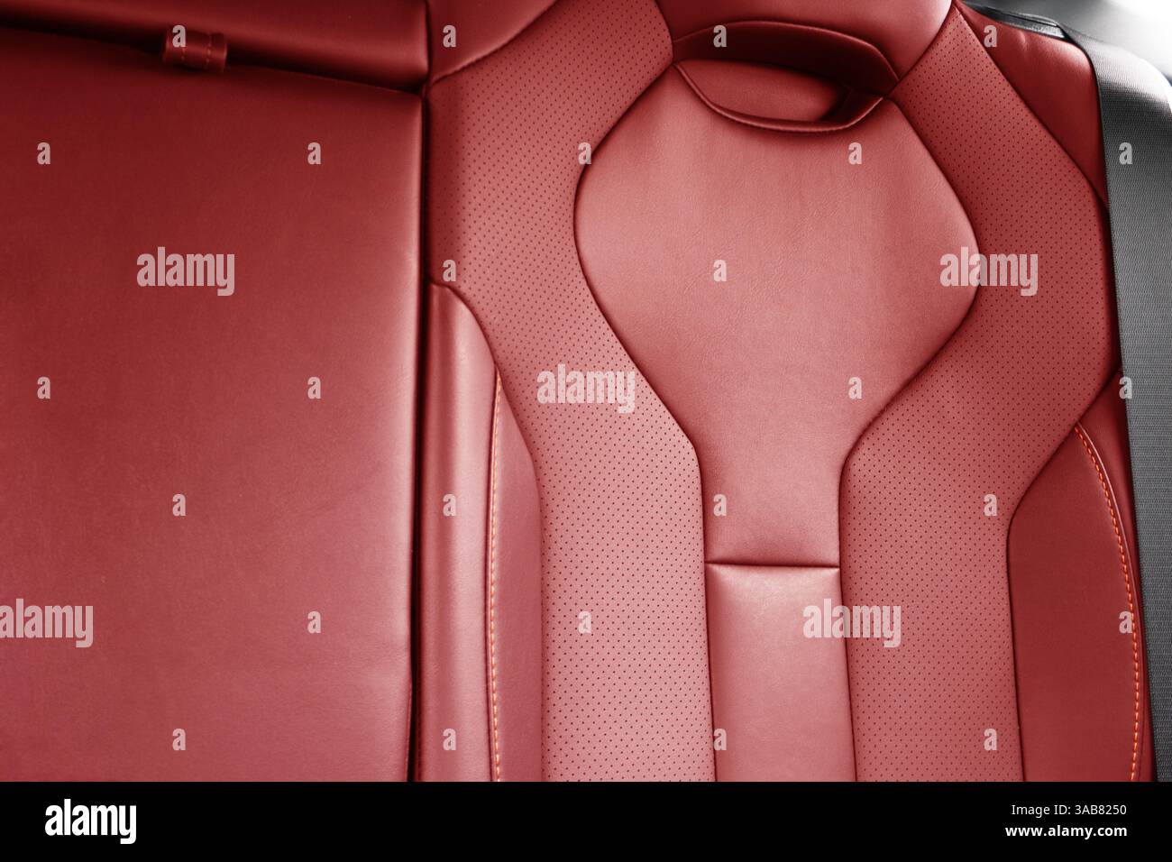 Sièges arrière rouges passager dans une voiture de luxe moderne. Cuir perforé rouge avec coutures blanches. Détails de la voiture. Sièges confortables en cuir. Intérieur de voiture detai Banque D'Images