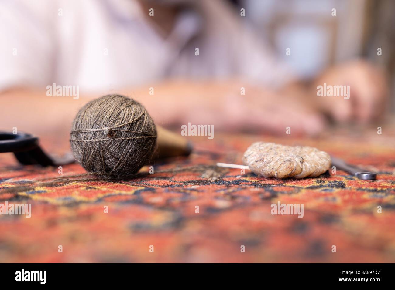 Le maître iranien recadré méticuleusement méconnaissable travaille dans son atelier de Salzbourg, restaurant des tapis exquis et rares avec des techniques traditionnelles, spectacle Banque D'Images
