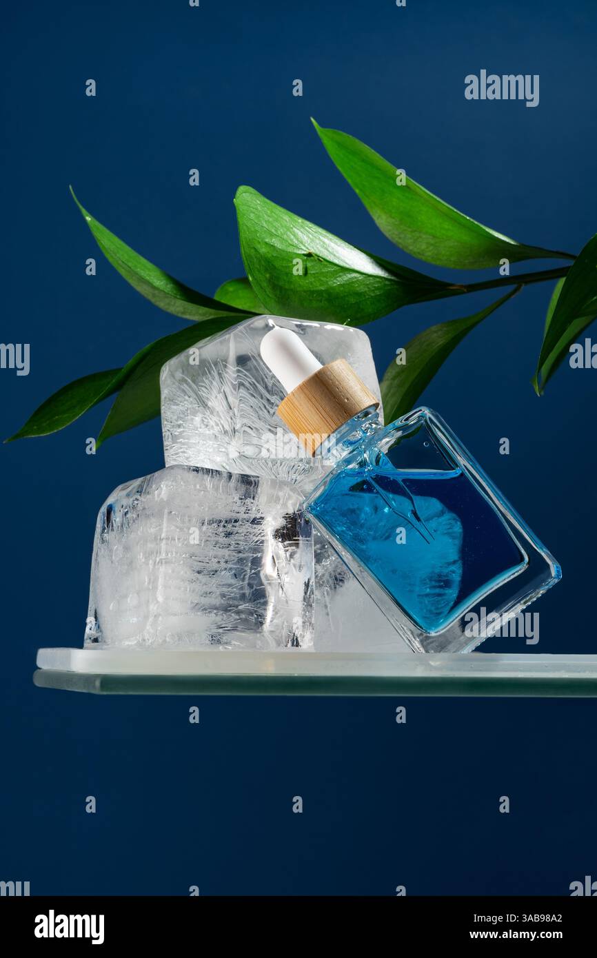 Un sérum de soin du visage rafraîchissant dans un flacon compte-gouttes pour hommes, mettant l'accent sur un effet frais et revigorant. La pipette est montrée dans un plan macro, nestling Amon Banque D'Images