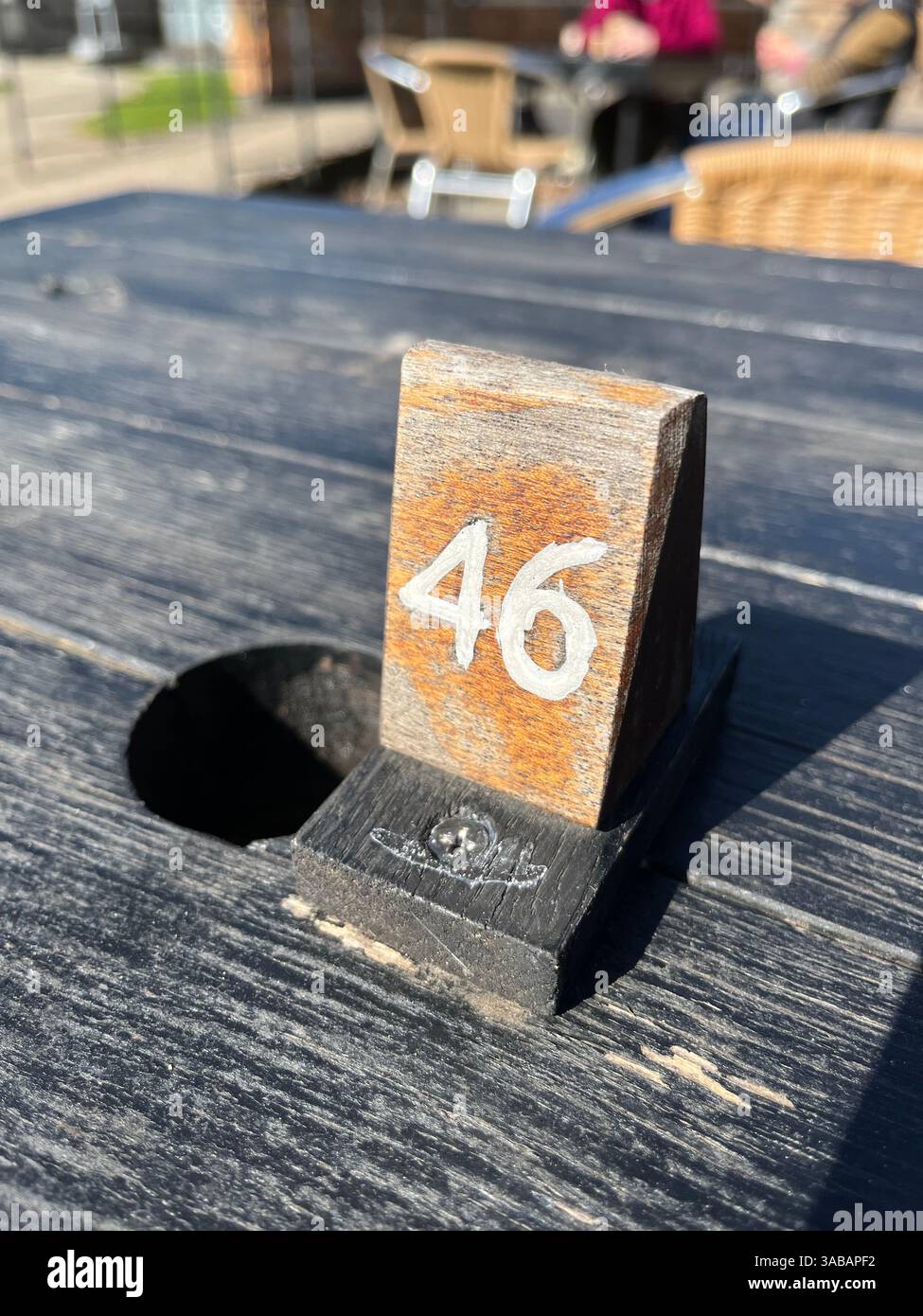 Numéro de table en bois sur un restaurant extérieur ou une table de café. Surface altérée. Numéro 46. Banque D'Images