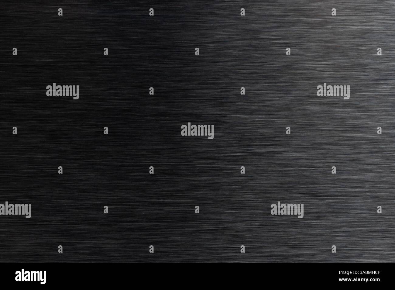 La lumière se reflète sur une surface métallique sombre et élégante présentant une texture lisse et brossée dans un cadre contemporain. Banque D'Images