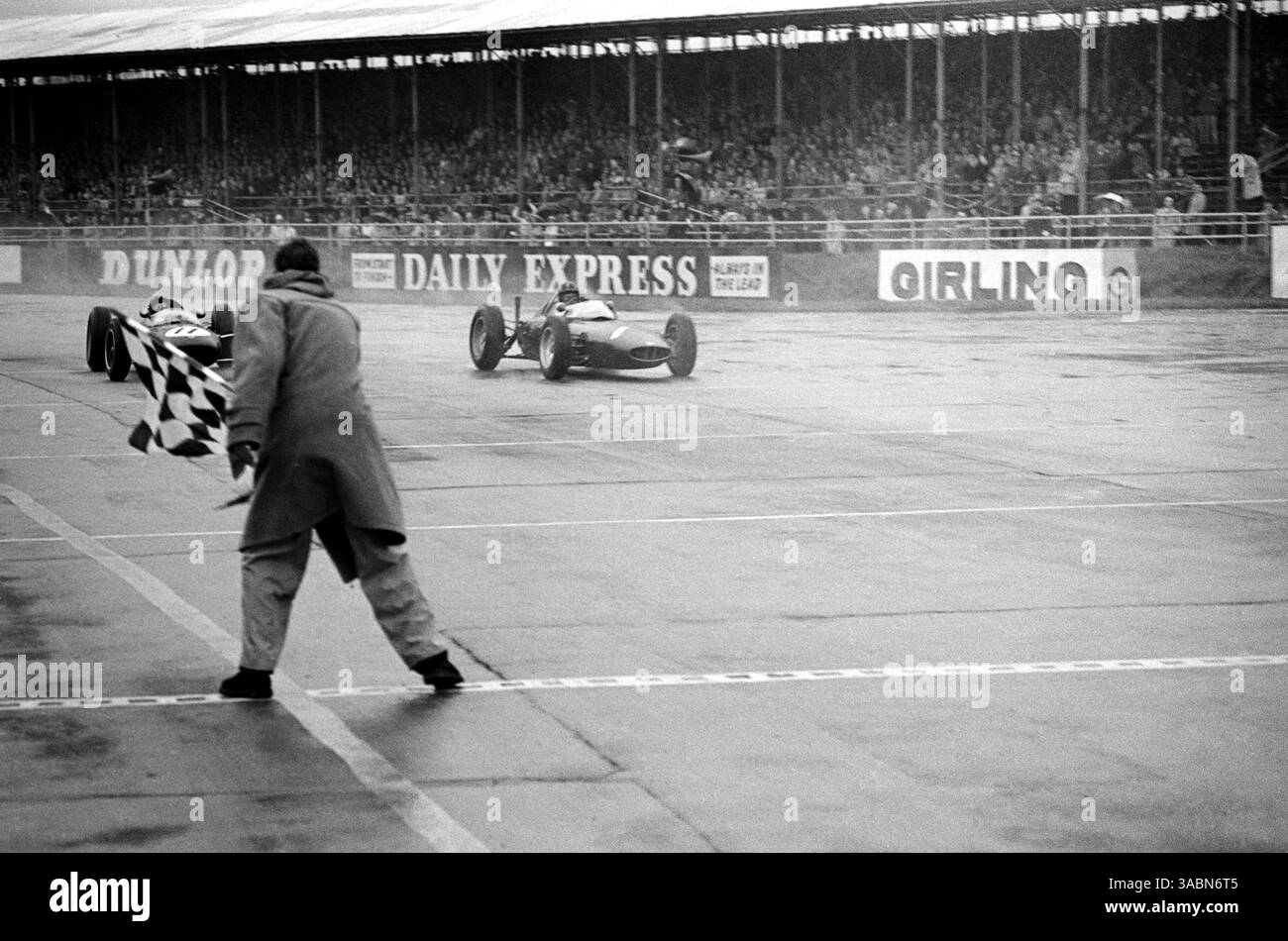 Le vainqueur de course Graham Hill (GBR) BRM P578 (à droite) bat Jim Clark (GBR) Lotus 24 (à gauche) au drapeau à damiers à la fin de la course. Les deux ont été donnés exactement au même moment..non Championship Formula One, BRDC International Trophy, Silverstone, Angleterre, 12 mai 1962. (Crédit image : ©Sutton Motorsports/ZUMA Press) Banque D'Images