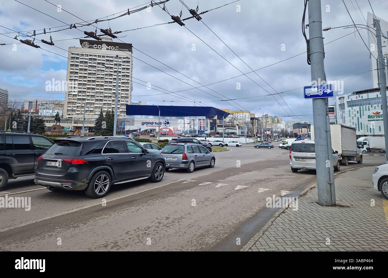 CHISINAU, MOLDAVIE - 20 mars 2024 circulation urbaine pendant les heures de pointe le matin au rond-point avec vue sur l'ancien bâtiment de l'hôtel Cosmos - Image de stock capturée avec un smartphone