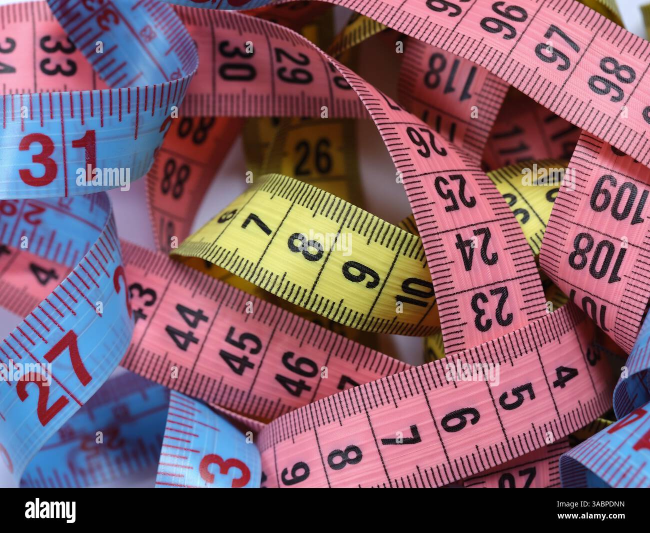 Un tas de rubans à mesurer colorés. Gros plan. Banque D'Images