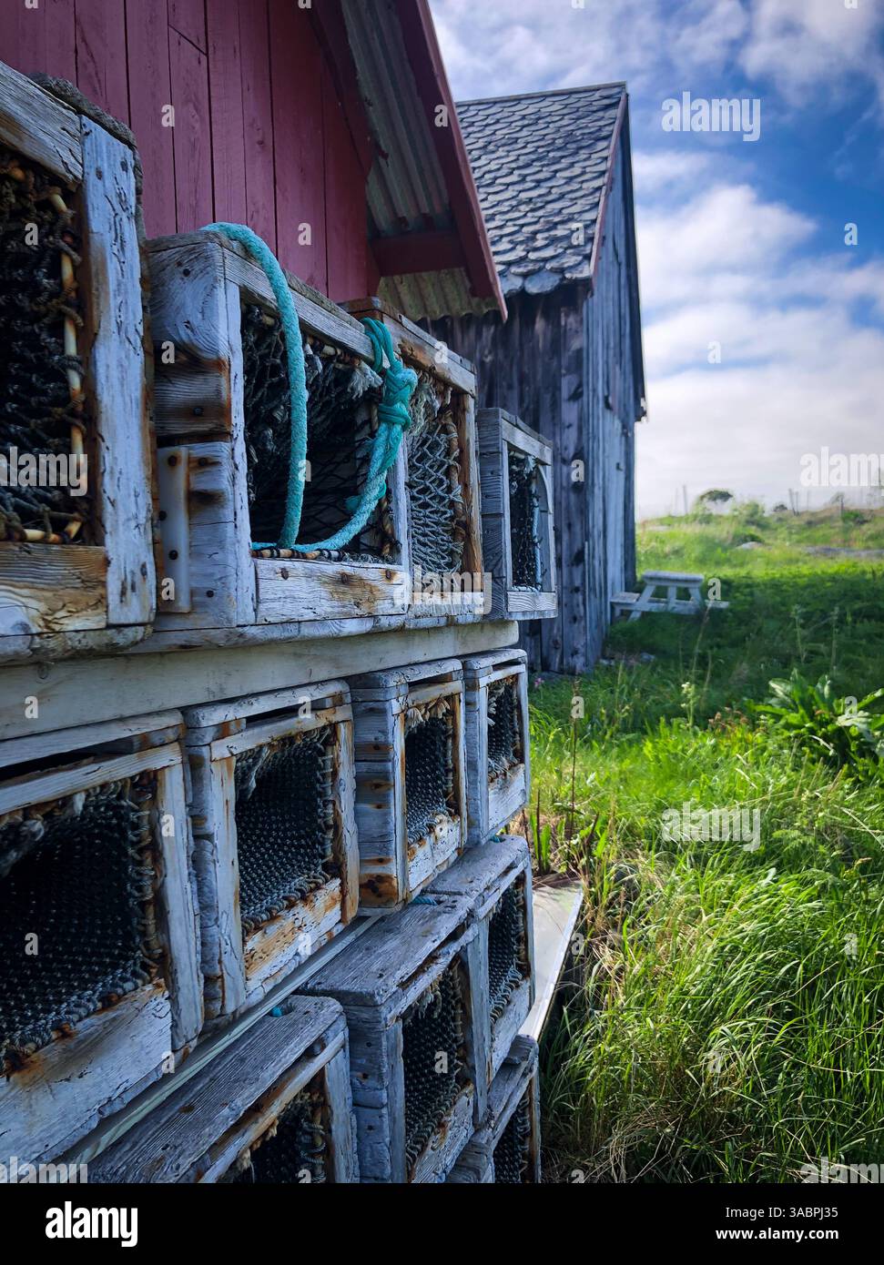 Vieux matériel de pêche au crabe derrière un hangar à bateaux Banque D'Images