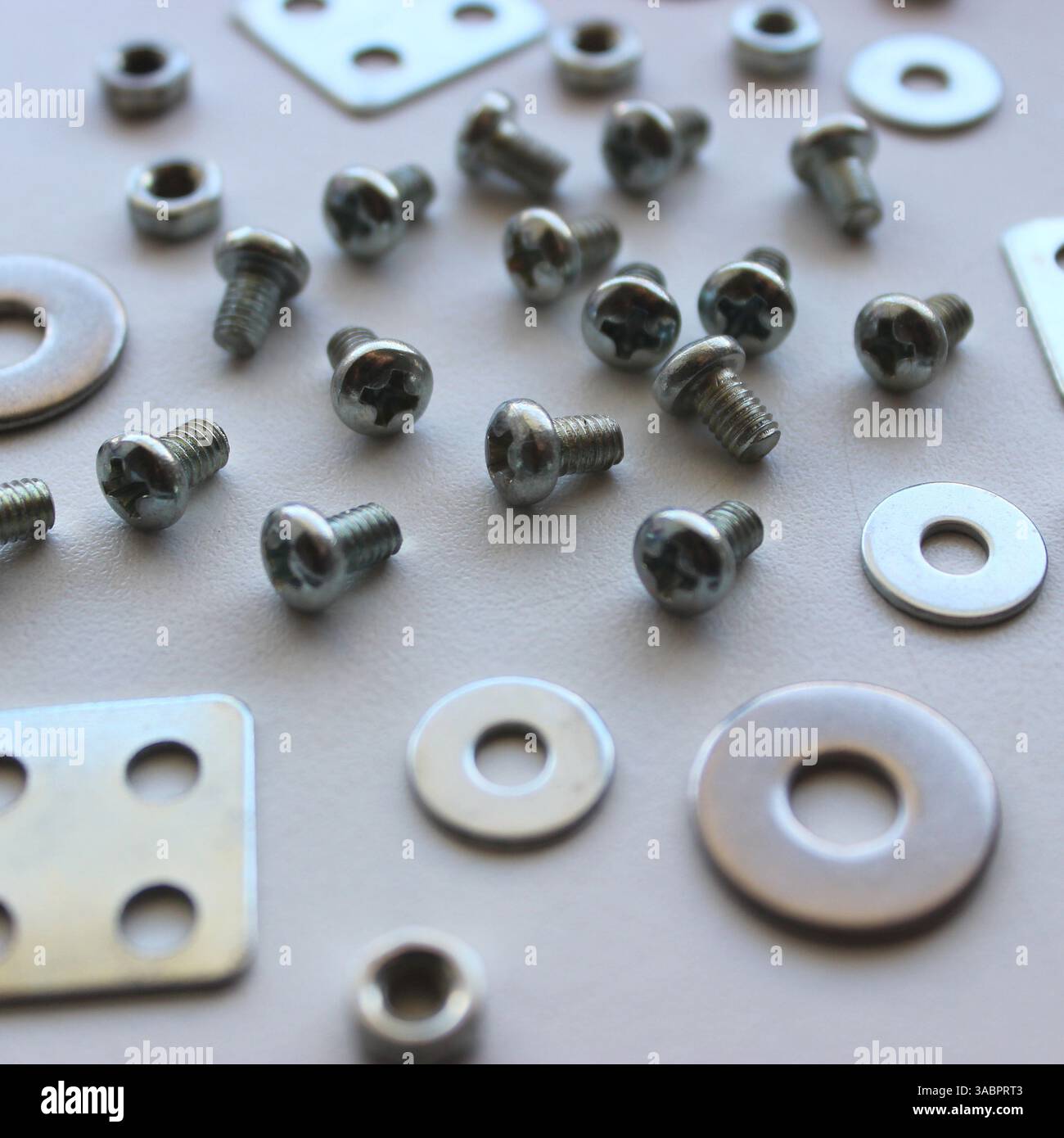 Variété attache en acier métallique et éléments de fixation dispersés sur la surface rayée Macro Shot photo stock. Arrière-plan libre de droits sur les articles de fer à repasser Banque D'Images