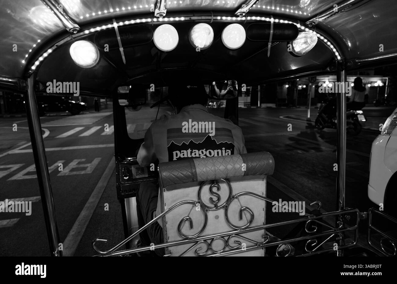 Naviguez dans les rues de Bangkok la nuit depuis la banquette arrière d'un tuk tuk classique en noir et blanc Banque D'Images