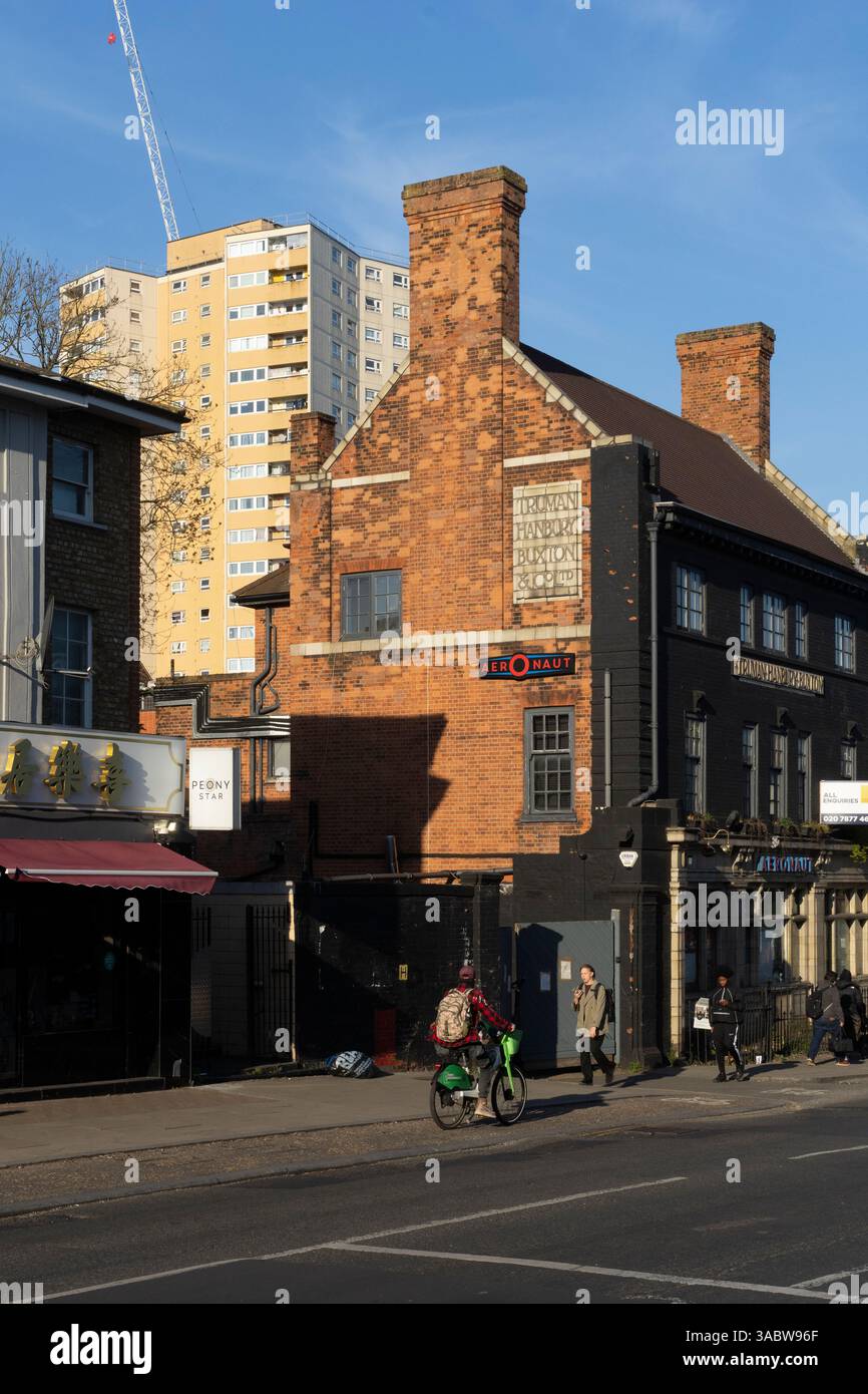 Piétons et cyclistes dans une rue de Londres, près du bâtiment Truman Hanbury Buxton & Co. La construction est en cours sur une tour voisine. Banque D'Images