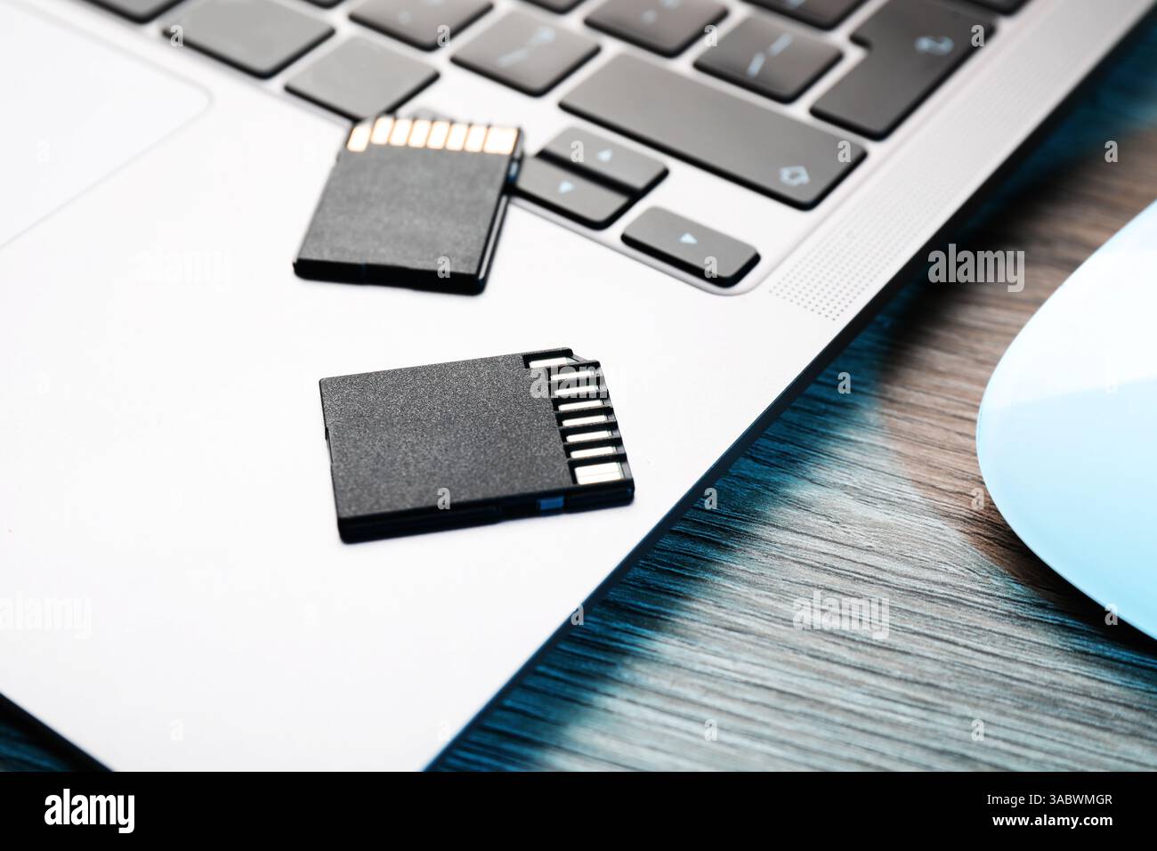 Cartes mémoire SD et ordinateur portable sur table en bois, gros plan Banque D'Images