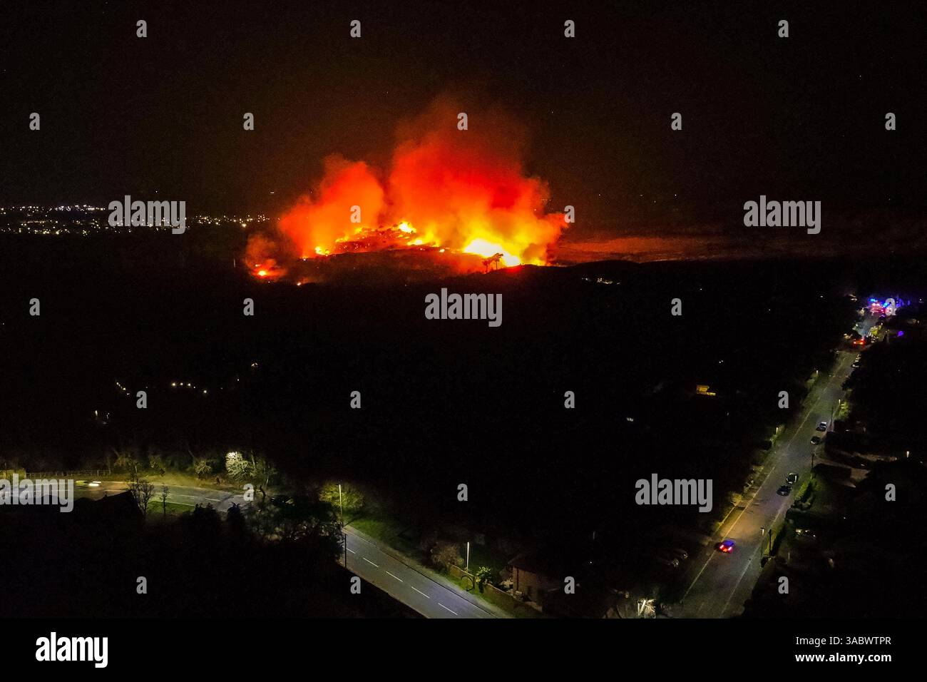 Poole, Dorset, Royaume-Uni. 3 avril 2025. Météo britannique. Vue aérienne vers un énorme feu de forêt qui flambe à Upton Heath à Poole dans le Dorset. Plusieurs services d'urgence sont présents, les voies étant fermées sur la voie de contournement A35 Upton en raison de la proximité de l'incendie. Ce dernier incendie dans la région de Bournemouth et Poole vient après une période de sécheresse prolongée avec des températures supérieures à la moyenne pour la période de l'année. Crédit photo : Graham Hunt/Alamy Live News Banque D'Images
