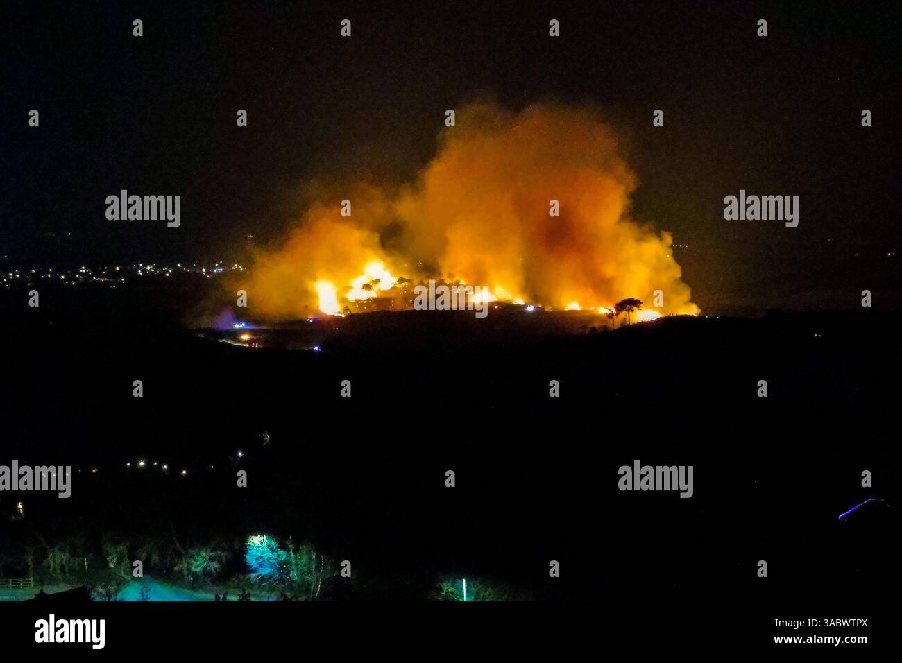 Poole, Dorset, Royaume-Uni. 3 avril 2025. Météo britannique. Vue aérienne vers un énorme feu de forêt qui flambe à Upton Heath à Poole dans le Dorset. Plusieurs services d'urgence sont présents, les voies étant fermées sur la voie de contournement A35 Upton en raison de la proximité de l'incendie. Ce dernier incendie dans la région de Bournemouth et Poole vient après une période de sécheresse prolongée avec des températures supérieures à la moyenne pour la période de l'année. Crédit photo : Graham Hunt/Alamy Live News Banque D'Images