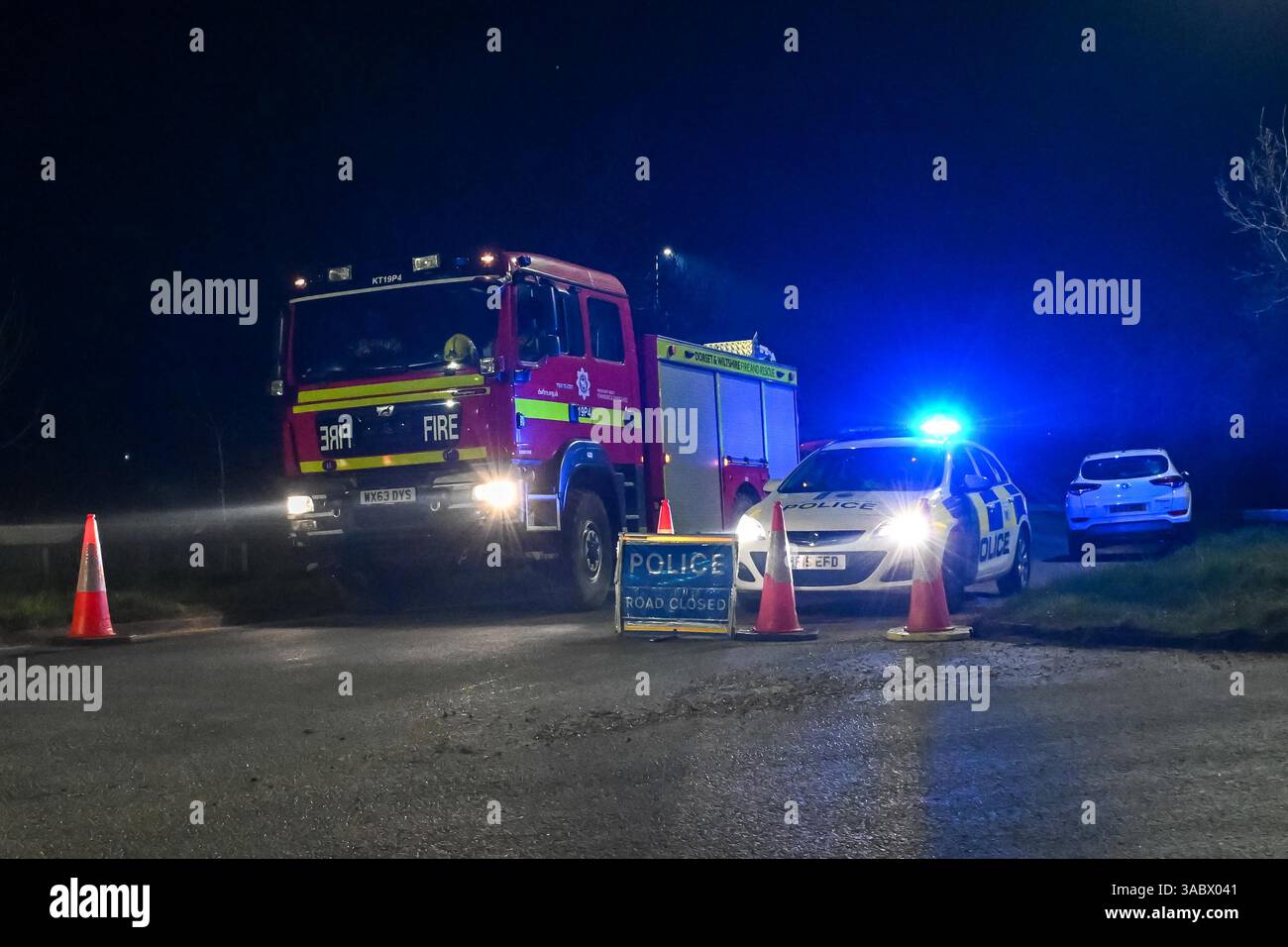 Poole, Dorset, Royaume-Uni. 3 avril 2025. Météo britannique. Un barrage routier de la police sur une bretelle d'accès à l'A350 vers le contournement d'Upton A35 où les pompiers stationnent avant de se diriger vers un énorme feu de forêt à Upton Heath à Poole dans le Dorset. De nombreux services d'urgence sont présents et le contournement A35 Upton fermé dans les deux sens en raison de la proximité de l'incendie. Ce dernier incendie dans la région de Bournemouth et Poole vient après une période de sécheresse prolongée avec des températures supérieures à la moyenne pour la période de l'année. Crédit photo : Graham Hunt/Alamy Live News Banque D'Images