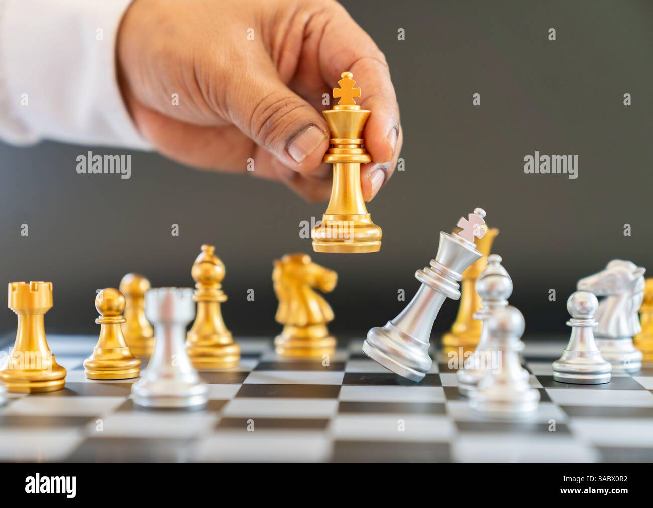 Gros plan main tenir le roi des échecs attact rival à bord, vérifier le concept de mate de la stratégie commerciale et du succès Banque D'Images