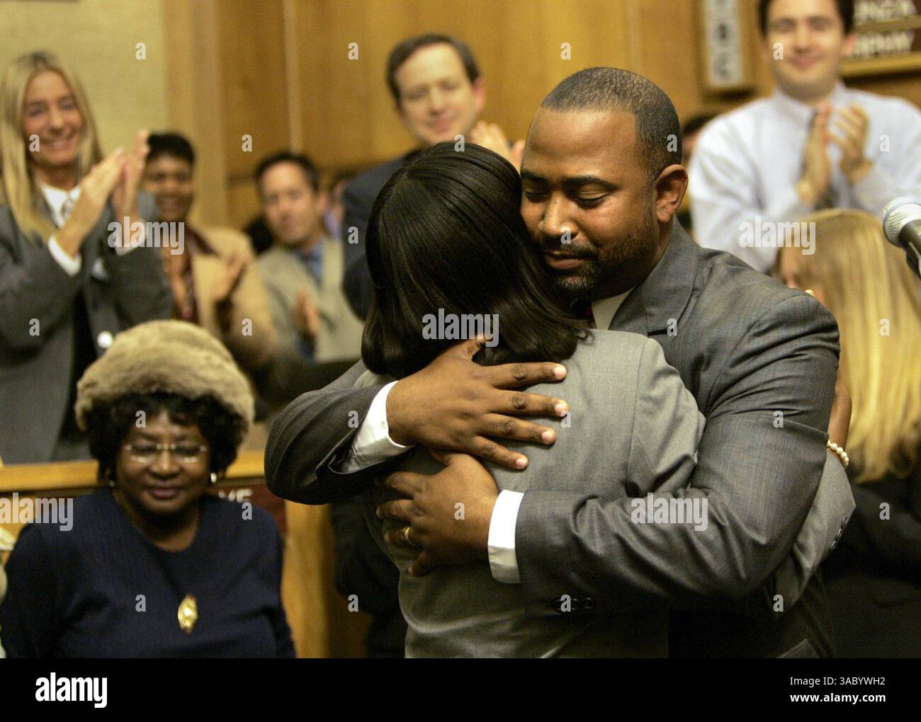 (Publié le 1/12/2005, B-1 :1,7, B-2 :6) le conseiller municipal de San Diego Tony Young, à droite, embrasse sa femme Jacque(cq)Young après avoir prêté serment pour remplacer le regretté Charles Lewis lors d'une cérémonie à l'hôtel de ville mardi matin. À gauche, Rosemary White-Pope, la mère de Charles Lewis. UT/John Gastaldo Banque D'Images