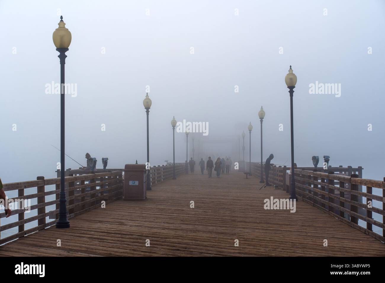 Oceanside, Californie - 3 janvier 2025 : matinée brumeuse sereine à Oceanside Municipal Pier avec pêcheurs et promeneurs tranquilles sur le bois Banque D'Images