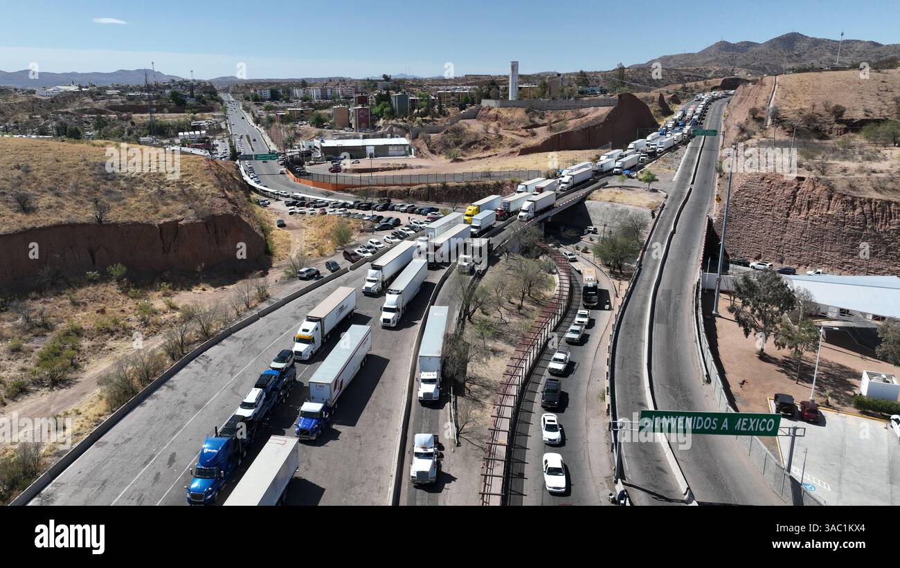 (250403) -- NOGALES, 3 avril 2025 (Xinhua) -- une photo de drone aérien montre un camion-remorque (en bas à gauche) transportant des véhicules sur une autoroute à Nogales, Sonora, Mexique, le 2 avril 2025. Le président américain Donald Trump a signé mercredi un décret sur les soi-disant « tarifs réciproques », imposant un « tarif de base minimal » de 10 pour cent et des taux plus élevés à certains partenaires commerciaux. Un tarif de 25 pour cent sur les voitures et les camions légers de fabrication étrangère est également entré en vigueur jeudi. Pour le Canada et le Mexique, les marchandises conformes à l'Accord États-Unis-Mexique-Canada (AEUMC) continueront d'afficher un taux de 0 % Banque D'Images