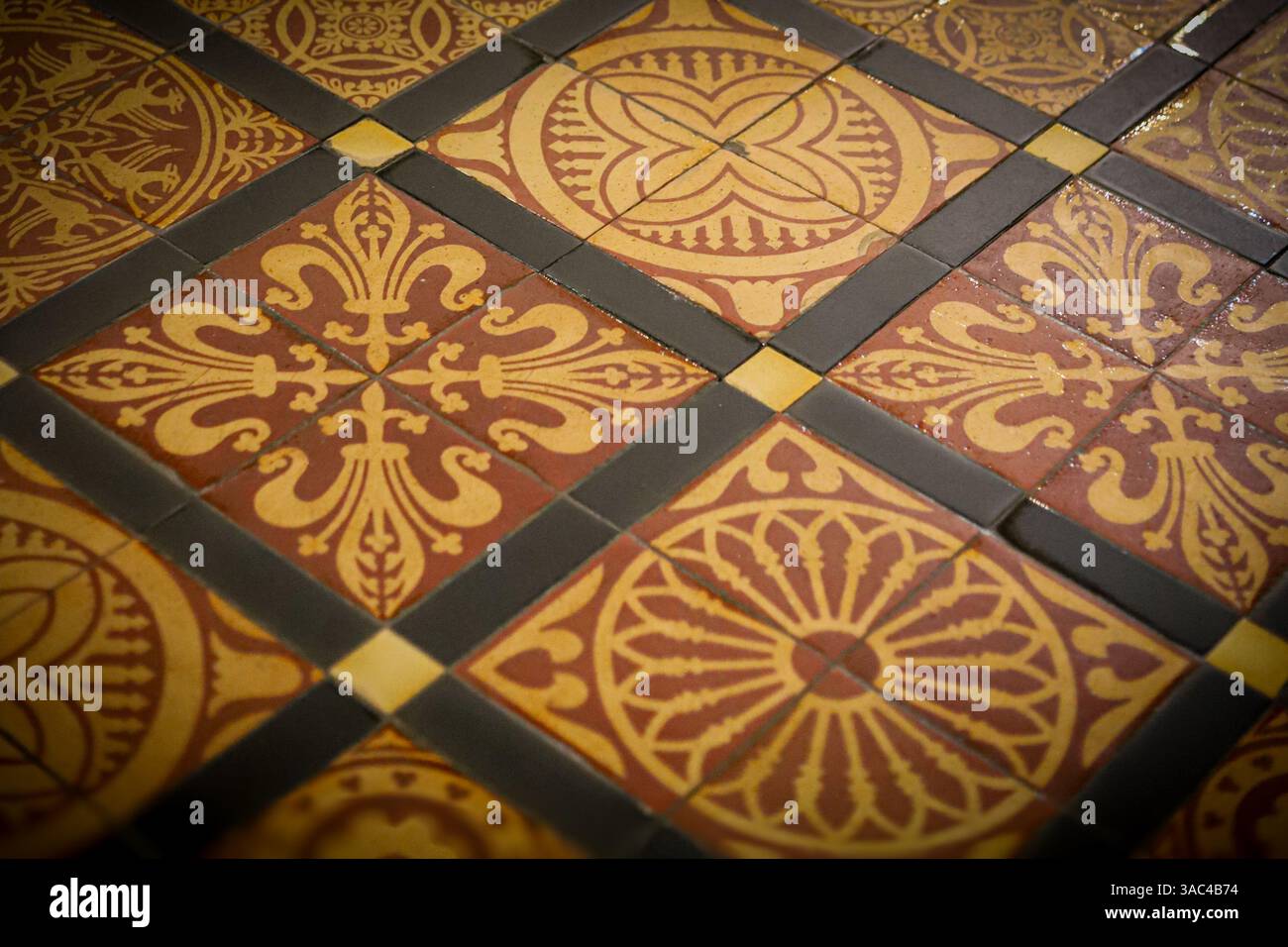 Photographie rapprochée du sol carrelé à motifs de la cathédrale de Rochester, en Angleterre, dans des tons terreux dorés Banque D'Images