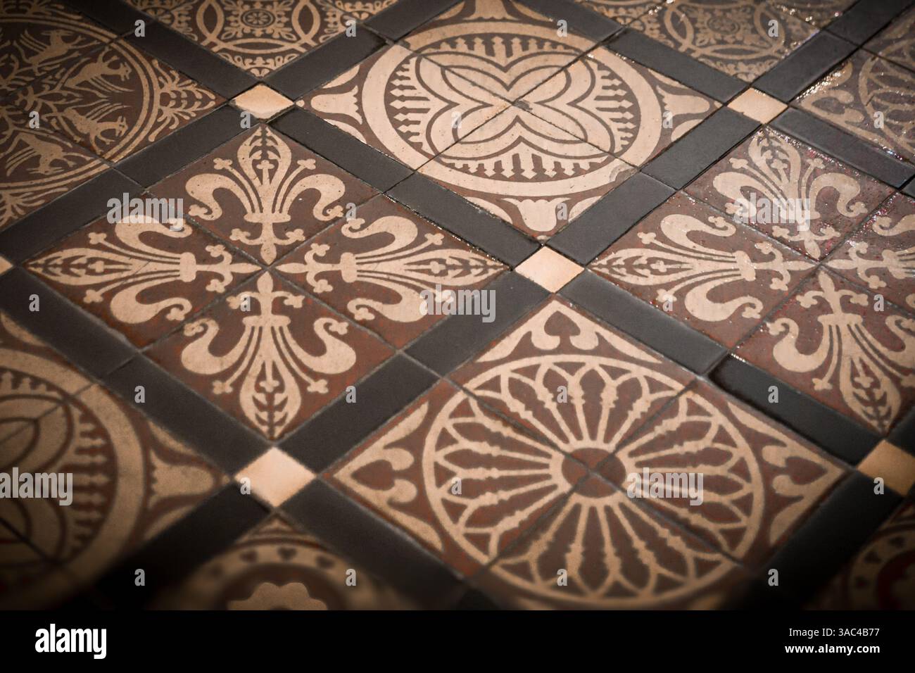 Photographie rapprochée du sol carrelé à motifs de la cathédrale de Rochester, en Angleterre, dans des tons terreux dorés Banque D'Images