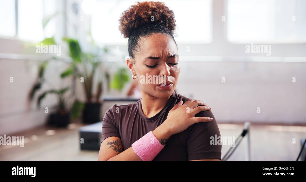Gymnase, fitness et femme avec douleur à l'épaule pour blessure, tension musculaire et inflammation en studio. Respiration, personne féminine et bien-être avec la main Banque D'Images