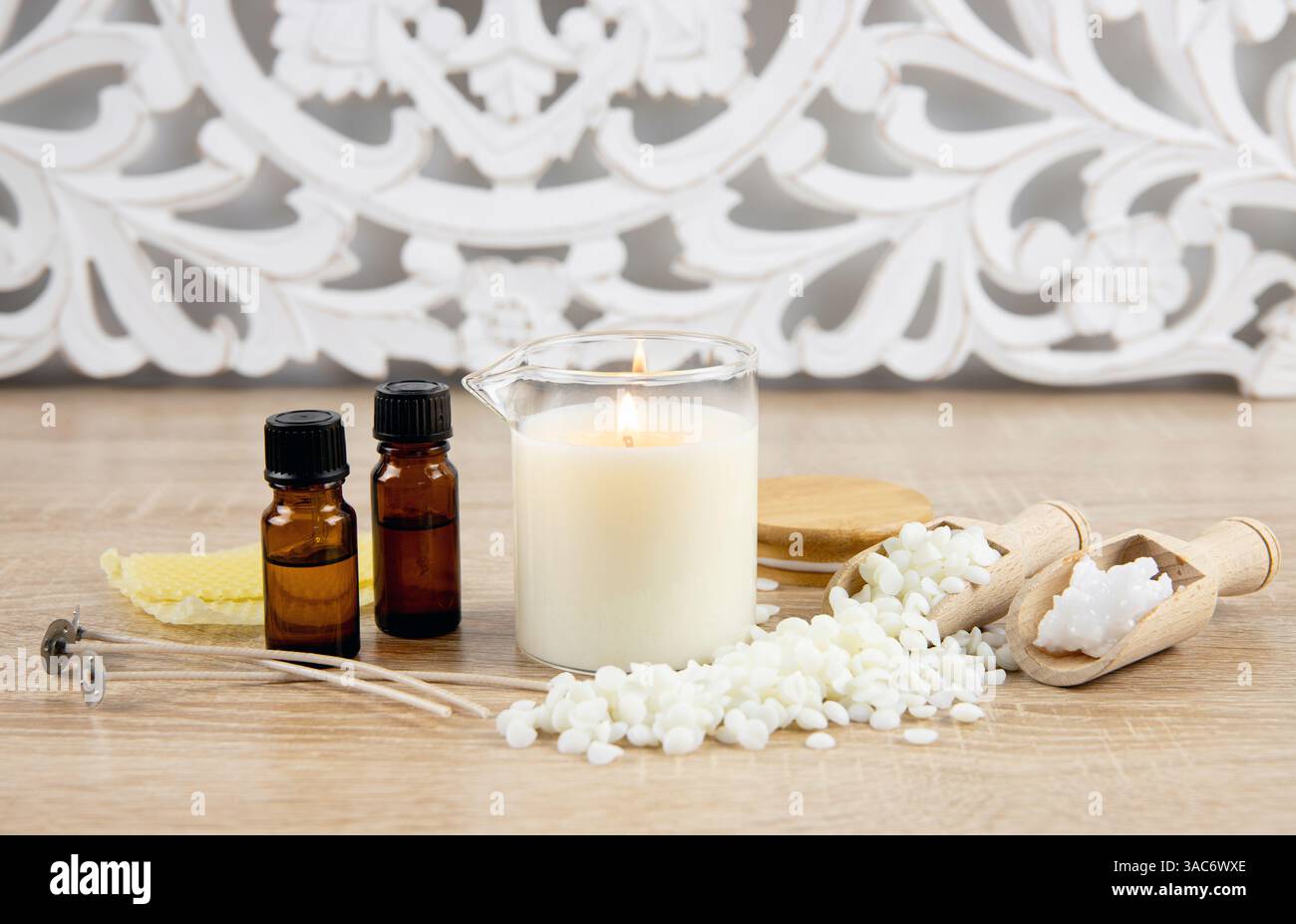 Concept de fabrication de bougie d'huile de massage maison parfumée. Outils, matériaux sur les bouteilles d'huile de parfum de table, pot en verre avec bec verseur, cire de noix de coco. Banque D'Images