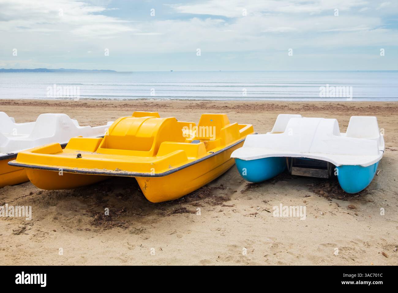 Pédalos colorés sur une belle plage tropicale. Pédalos garés sur la plage avec ciel bleu. Pédalos colorés. Photo de voyage, espace de copie, personne. Banque D'Images