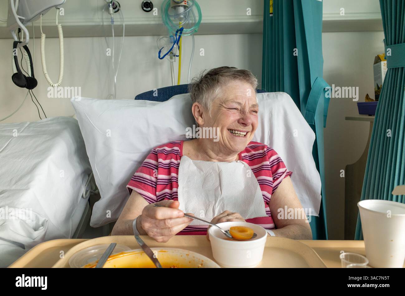 Heureuse patiente âgée riant dans son lit d'hôpital NHS, Angleterre, Royaume-Uni Banque D'Images Heureuse patiente âgée riant dans son lit d'hôpital NHS, Angleterre, Royaume-Uni Banque D'Images