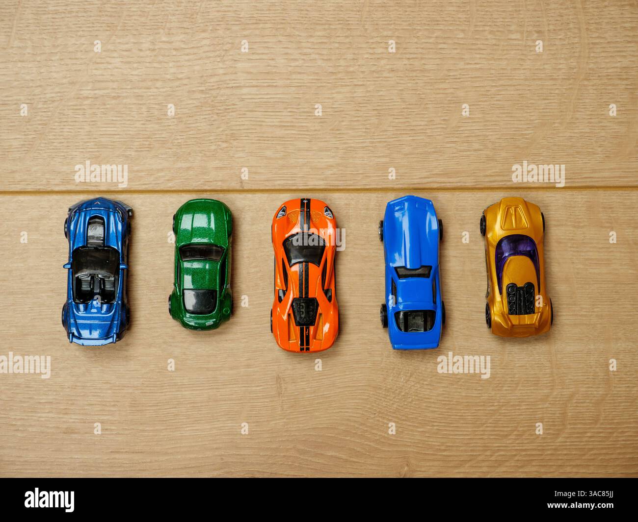 Des voitures jouets alignées sur des planches en bois avant le départ d'une course Banque D'Images