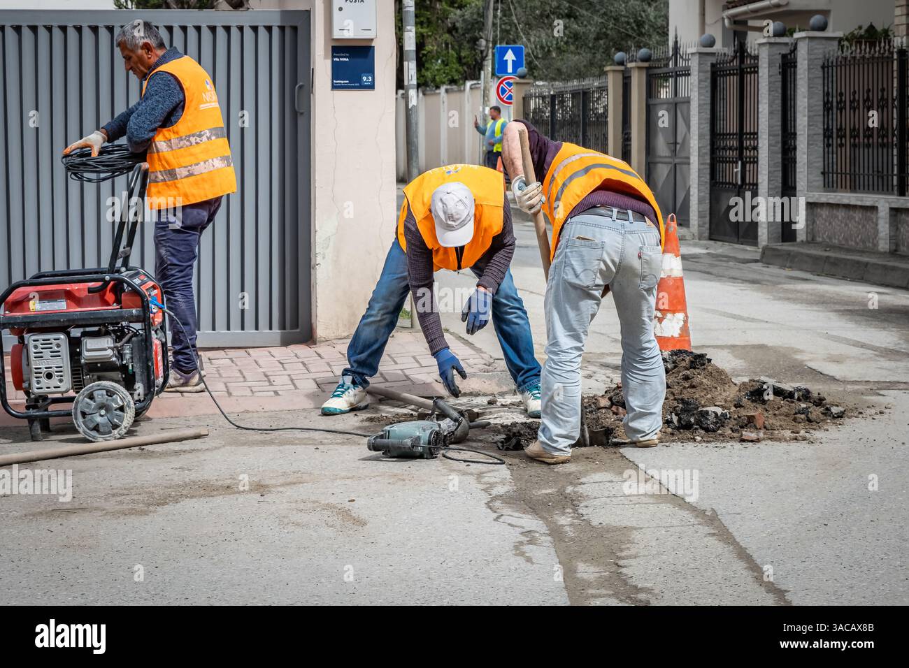 Ouvriers des services publics dans la rue utilisant un équipement spécial. Les plombiers se préparent à résoudre le problème dans l'égout. Travaux de réparation et d'entretien de rue extérieure, Banque D'Images