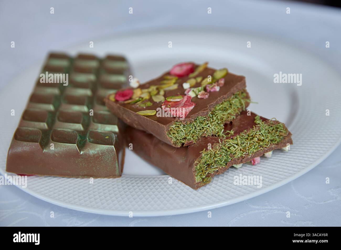Chocolat Dubaï. Un chocolat artisanal gourmand, tacheté de pistache vibrante et de framboise douce, invite à des moments de calme et de pur bonheur décadent Banque D'Images