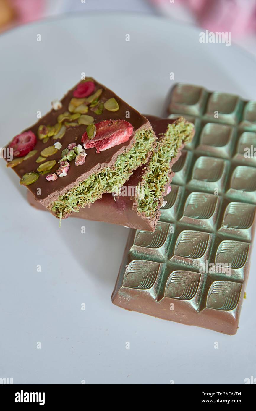 Chocolat Dubaï. Le chocolat artisanal rayonnant, orné de pistaches, de roses et de délicats pétales, évoque une ambiance tendre et romantique pour de douces gourmandises, Banque D'Images
