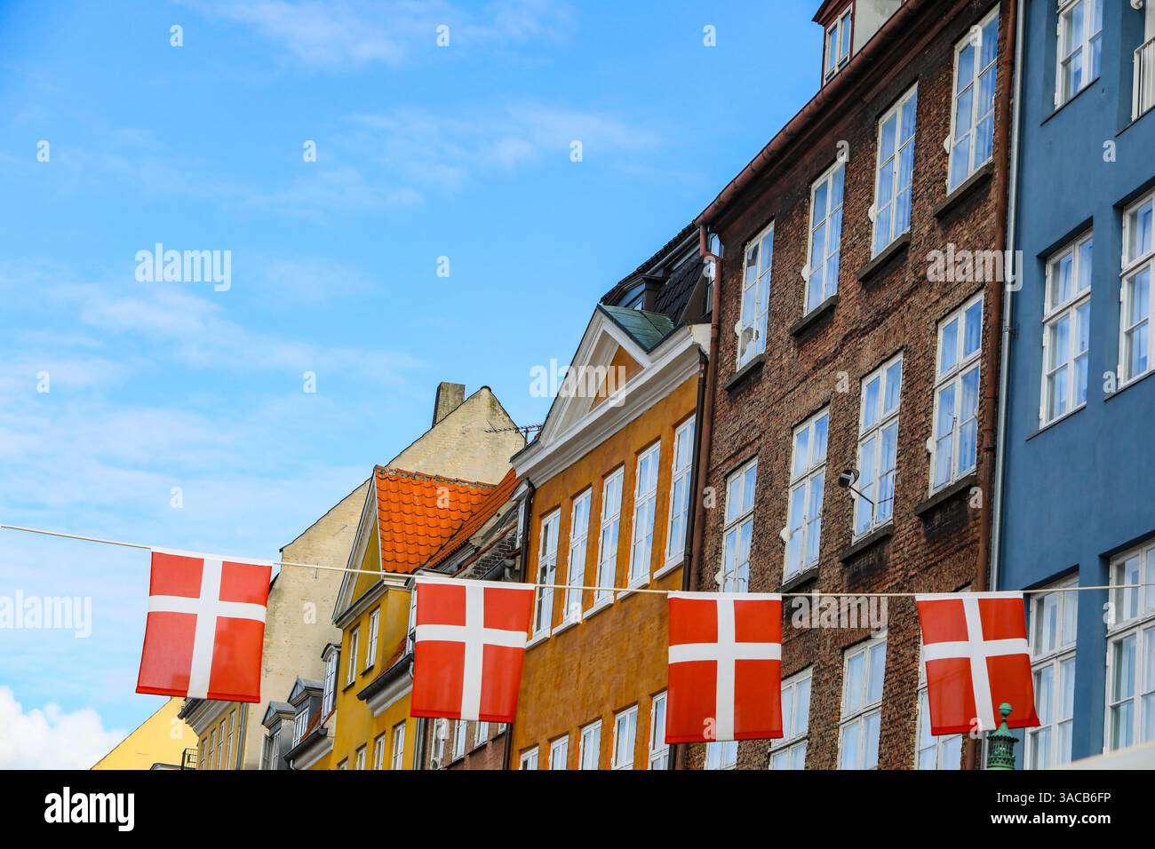 Copenhague, Danemark. Nyhavn zone, maisons peintes colorées, drapeau du Danemark. Banque D'Images