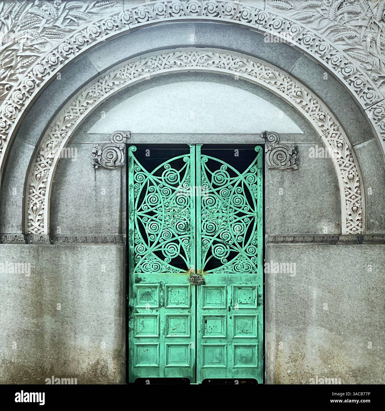 Des portes en bronze vert élaborées avec des volutes tourbillonnantes et un motif d'étoile central marquent l'entrée d'un tombeau historique de Chicago. - Image de stock capturée avec un smartphone